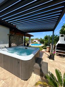 a hot tub under a pergola on a patio at Vila La Perla Istriana in Višnjan