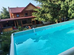 een groot blauw zwembad voor een huis bij Susurul Apei Chalet in Porumbacu de Sus