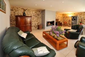 a living room with a leather couch and a coffee table at Le Logis du Marronnier in Perpezac-le-Noir