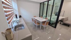 eine Küche mit Tisch und Stühlen und einer Spüle in der Unterkunft One Point Hotel TT3 Tabuan Tranquility in Kuching
