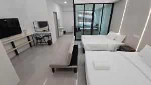 ein Hotelzimmer mit zwei Betten und einem Fernseher in der Unterkunft One Point Hotel TT3 Tabuan Tranquility in Kuching