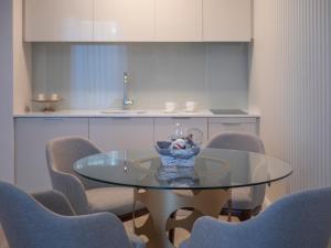 a dining room with a glass table and chairs at CASA AL MARE RESIDENCE in Bečići