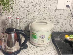 a tea kettle and a toaster on a kitchen counter at MaryJun LN Loft Room in Kon Rung (1)