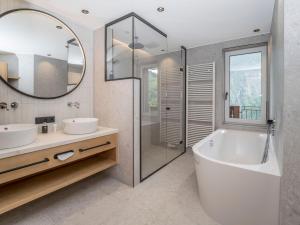 ein Badezimmer mit zwei Waschbecken und einer Badewanne und einem Spiegel in der Unterkunft die Aussicht in Finkenberg + 80 Fotos