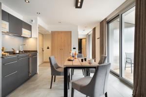 a kitchen and dining room with a table and chairs at MGM Hôtels & Résidences - Résidence Alhéna in Flaine