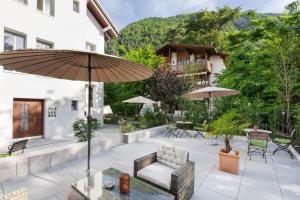 a patio with an umbrella and chairs and tables at BetweenLakes Studio 2nd floor in Interlaken +4 photos
