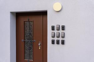 a door with a clock and cell phones on a wall at BetweenLakes Studio 2nd floor in Interlaken