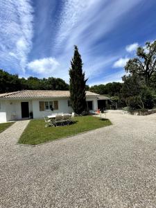 a house with a table and chairs in the driveway at Villa aux portes du médoc in Saint-Aubin-de-Médoc