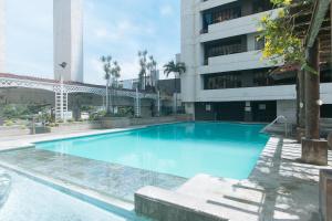 a large blue swimming pool in front of a building at Winland JY7 Cebu by RedDoorz in Cebu City