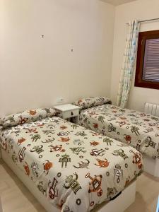 a bedroom with two beds and a bedspread with robots on it at El Valle Golf Resort in Baños y Mendigo +27 photos