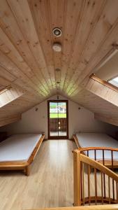 two beds in a room with a wooden ceiling at Wichtel Haus in Oberau