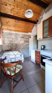 a kitchen with a table and a wooden ceiling at Rustical Apartment in Korčula