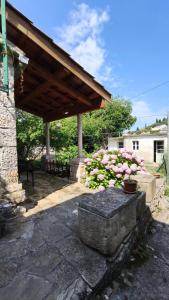 a stone patio with a wooden roof and flowers at Rustical Apartment in Korčula