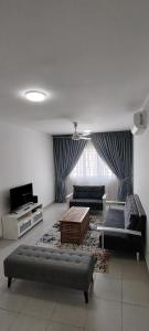 a living room with two couches and a tv at J&K Guesthouse at Harmoni Apartment, Eco Majestic in Beranang +40 photos