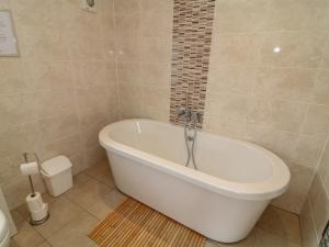 a white bath tub in a bathroom with a toilet at James Ville Marina Lodge 14 in Brigg +31 photos