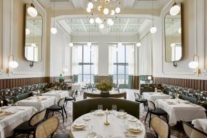 a restaurant with white tables and chairs and a chandelier at ON Residence - Small Luxury Hotels of the World in Thessaloniki +32 photos