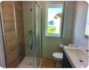a bathroom with a shower and a toilet and a sink at Apartamento El Muro in Laredo +7 photos