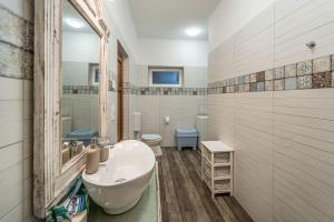 a bathroom with a sink and a toilet and a mirror at Vénhegyi Levendula Vendégház Mór in Mór +18 photos