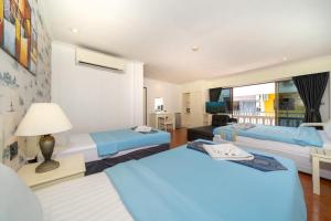 a hotel room with two beds and a window at Patong Central Residence & Apartment in Patong Beach +78 photos