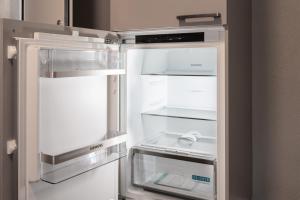 an empty refrigerator with its door open in a kitchen at BetweenLakes Studio 2nd floor in Interlaken