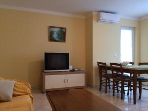 a living room with a tv and a dining room table at Apartment Ana in Poreč