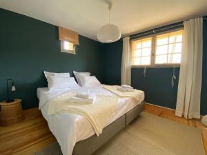 een slaapkamer met een groot bed met witte lakens bij Villa Férus Piscine chauffée in Buis-les-Baronnies