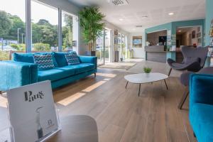 a living room with a blue couch and a table at Résidence Prestige Odalys Le Domaine des Pins in Noirmoutier-en-l'lle