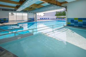 a large swimming pool with blue water at Résidence Prestige Odalys Le Domaine des Pins in Noirmoutier-en-l'lle