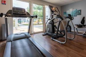 a gym with two exercise bikes and a treadmill at Résidence Prestige Odalys Le Domaine des Pins in Noirmoutier-en-l'lle