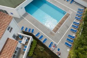 an overhead view of a swimming pool with chairs at Résidence Prestige Odalys Le Domaine des Pins in Noirmoutier-en-l'lle +37 photos