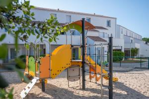 a playground in front of a building at Résidence Prestige Odalys Le Domaine des Pins in Noirmoutier-en-l'lle