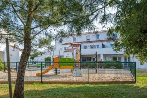 a playground with a slide in front of a building at Résidence Prestige Odalys Le Domaine des Pins in Noirmoutier-en-l'lle