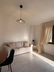 a living room with a white couch and a table at CasaNica - Elegant independent apartment in Torpè