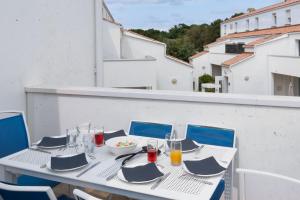 a white table with a bowl of food on a balcony at Résidence Prestige Odalys Le Domaine des Pins in Noirmoutier-en-l'lle