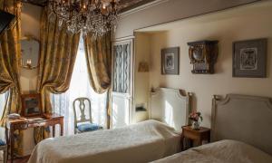 a bedroom with two beds and a window at Hotel Caron de Beaumarchais in Paris