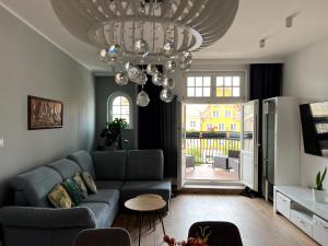 a living room with a couch and a chandelier at Diamond Apartment in Grudziądz