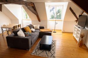 a living room with a couch and a table at Grand duplex en plein centre in Cernay