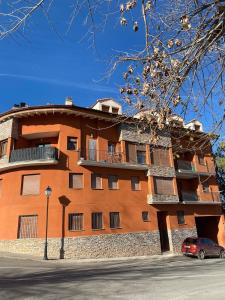 a orange building with a car parked in front of it at Ático con chimenea en Bronchales in Bronchales