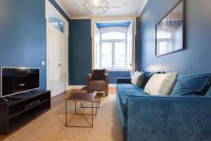 uma sala de estar azul com um sofá azul e uma cadeira em FLH Baixa Blue Apartment em Lisboa