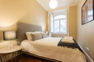 Uma cama ou camas num quarto em FLH Baixa Blue Apartment