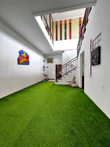 an empty room with green carpet in a building at Remedy in Lagas in Ubud