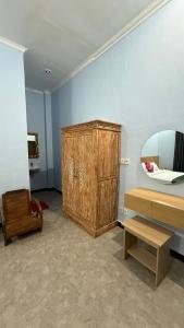 a room with a wooden cabinet and a mirror at Remedy in Lagas in Ubud