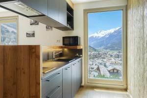 a kitchen with a large window with a mountain view at Lidia & Orfeo in Bormio