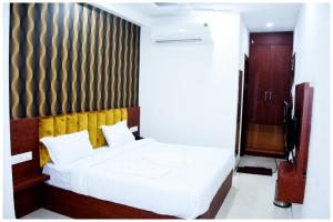 a bedroom with a white bed with a wooden headboard at HOTEL !! LUXUARY GANGA AMIRT HARIDAWR - Near # Ganga Ghat 200M - Free Parking & Restaurant and Lift Facilities - Fully #Air Conditioning - A Top Rated Hotel! in Kankhal
