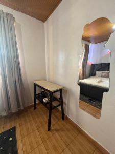 a small room with a bed and a table at Eldoret Hideout Cozy 1-Bed Along Kisumu Road Near Tamasha in Eldoret