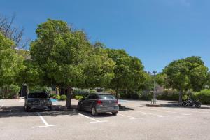 two cars parked in a parking lot with trees at Premiere Classe Toulon La Seyne-sur-Mer in La Seyne-sur-Mer
