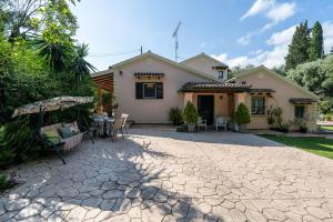 een huis met een patio met een tafel en een parasol bij Arilia Country Cottage in Danilia