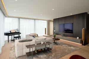 a living room with a couch and a tv and a piano at Castle View Penthouse in Ljubljana