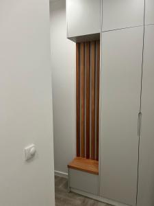 ein Raum mit einem weißen Schrank und einer Holzbank in der Unterkunft Lumar in Bar