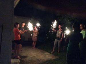 a group of people holding sparklers in the dark at Fern Dale in Weligama